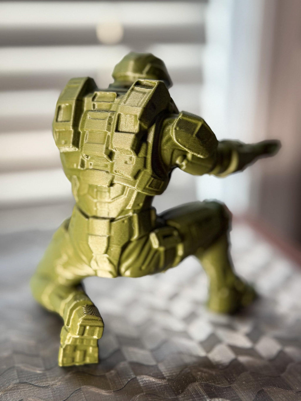 Green superhero figurine on a textured surface with blurred background